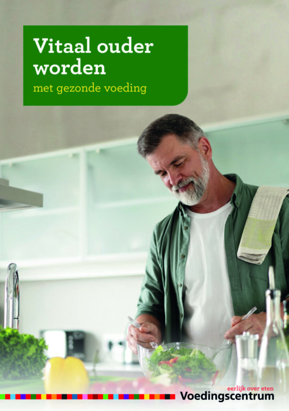 Vitale man die een salade maakt in de keuken